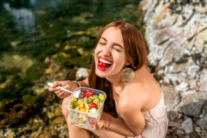 This young woman is enjoying her healthy lunch of fresh raw vegetables for feeding her gut bacteria to affect her brain through gut-brain axis