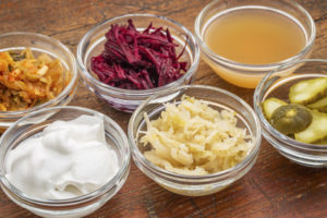 Bowls of fermented foods to strengthen your gut microbiome and fight depression: kimchee, sauerkraust, yogurt