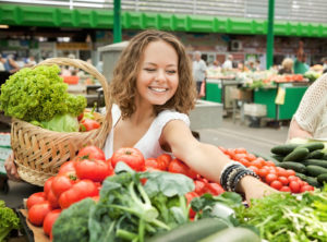 Young woman buying fresh vegetables to support her microbiome and mood