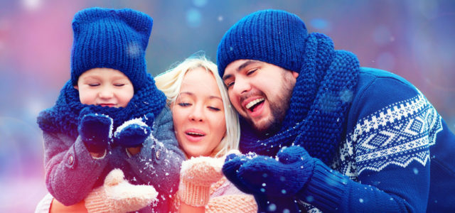 Photo of family catching snowflakes who have found happiness in their relationships illustrates the social principle of the Science of Happiness.