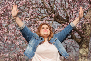 Grateful woman with arms upraised, overcoming tragedy with attitude of gratitude