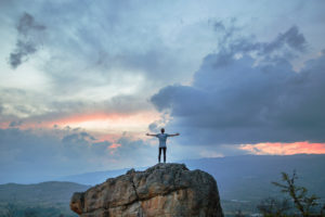 Man on top of mountains spreads arms in relief - IV ketamine doing what prozac can't.