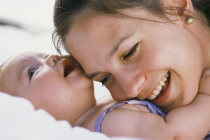 Mom plays and hugs baby because nourishes newborn neuron growth.