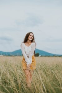 This happy young woman in this field is glad that neuroscience discoveries fight stigma. Ketamine treatment has stopped her suffering.